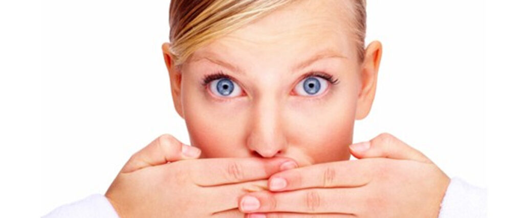 A person with blonde hair and blue eyes is looking directly at the camera with a surprised expression, covering their mouth with both hands. The background is white, making this scene perfect for a slide template or PowerPoint presentation.